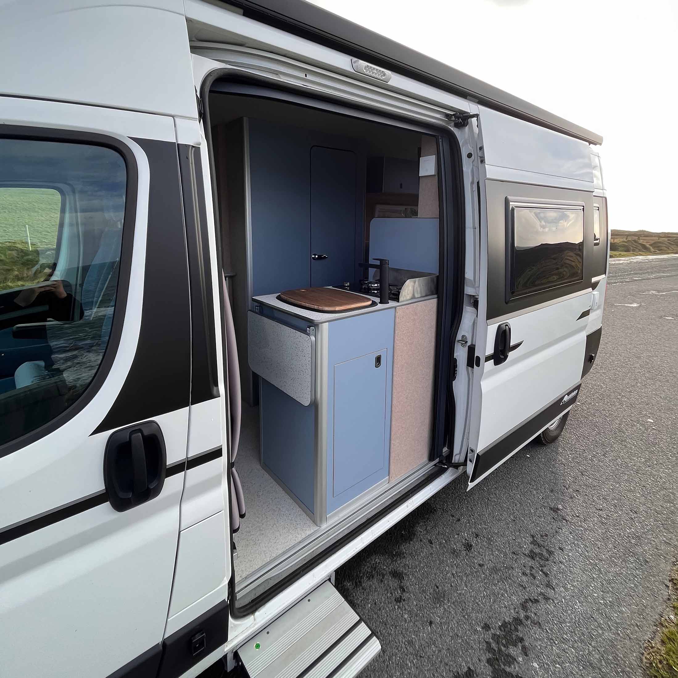 side of white van with door open showing the blue interior
