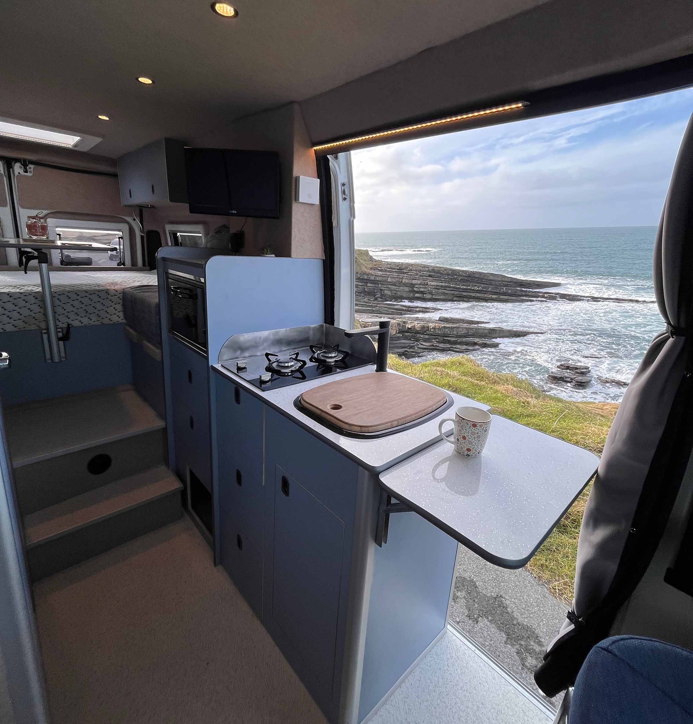van with blue kitchen unit with side door open on van