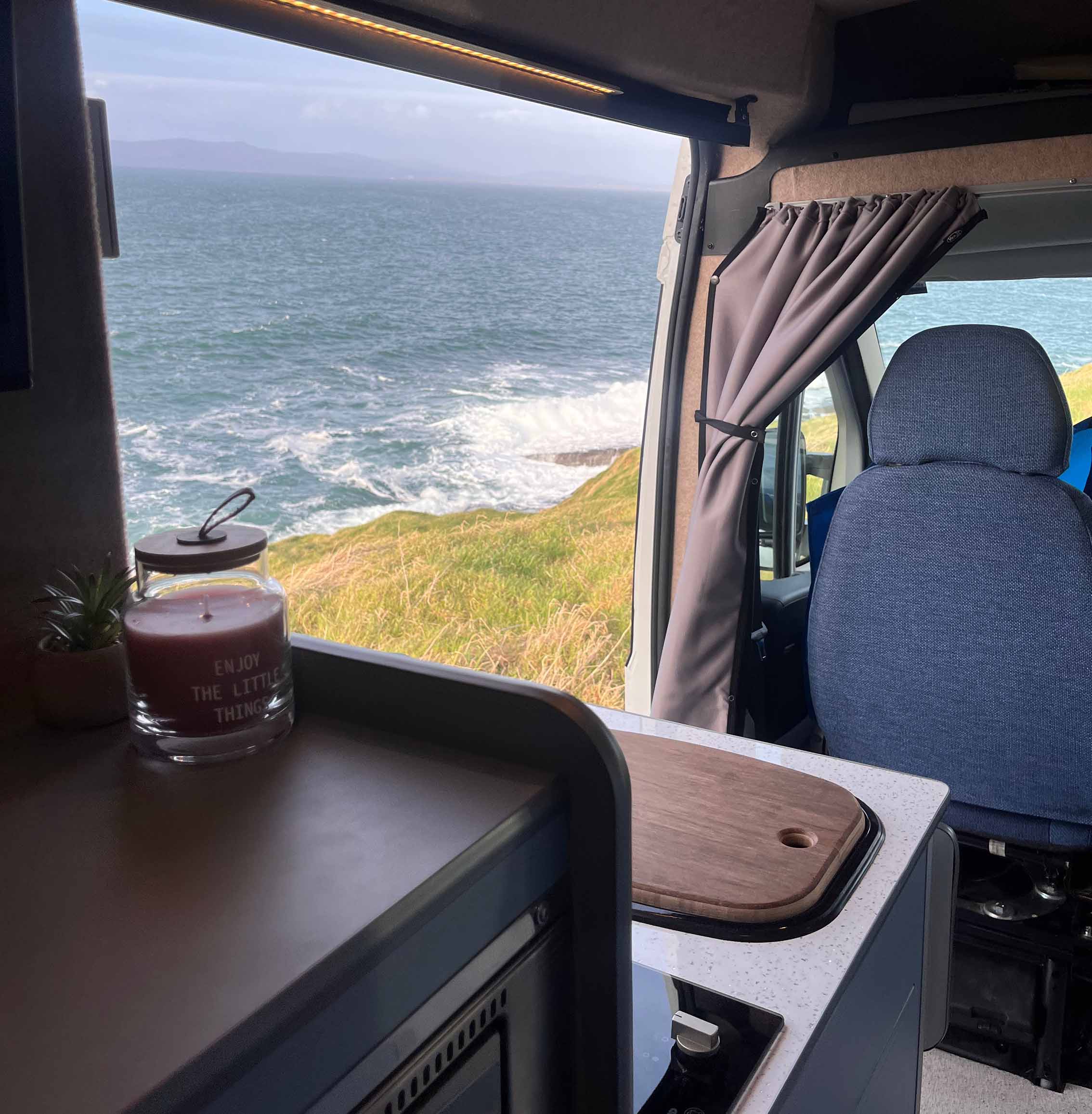 inside van with side door opened showing the beach outside