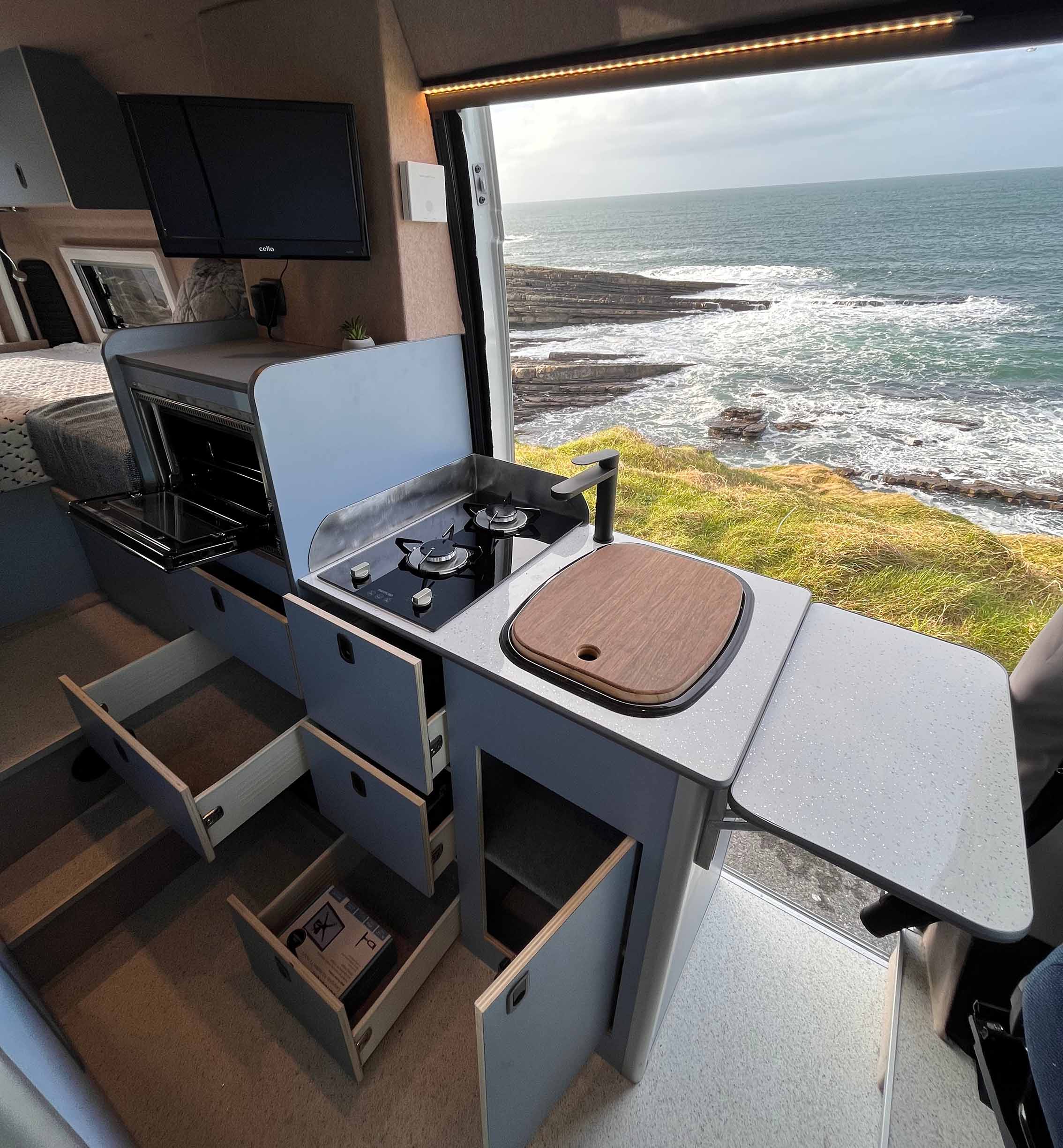 blue kitchen unit with all the drawers and doors open
