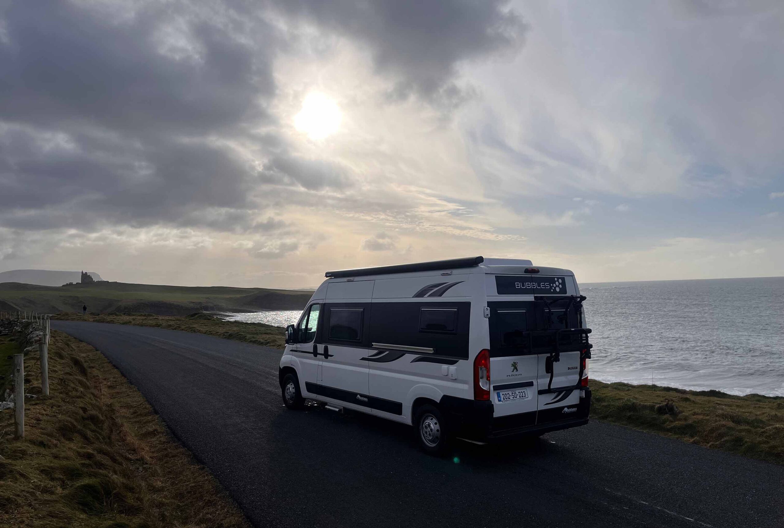 side view of white van with the sea in the background